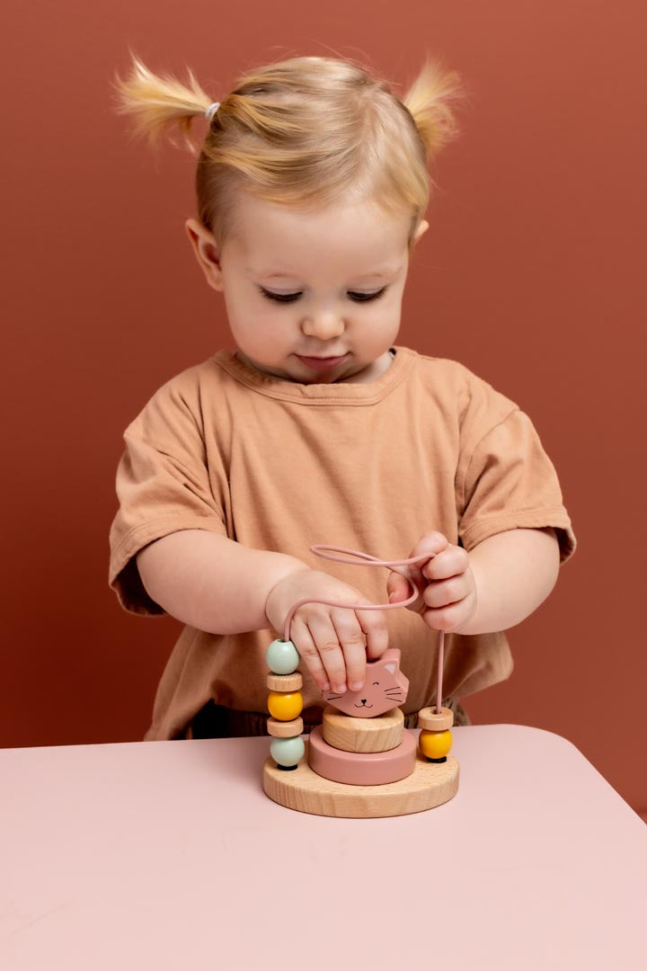 Toddler hand sliding beads on Trixie Mrs. Cat fine motor maze toy
