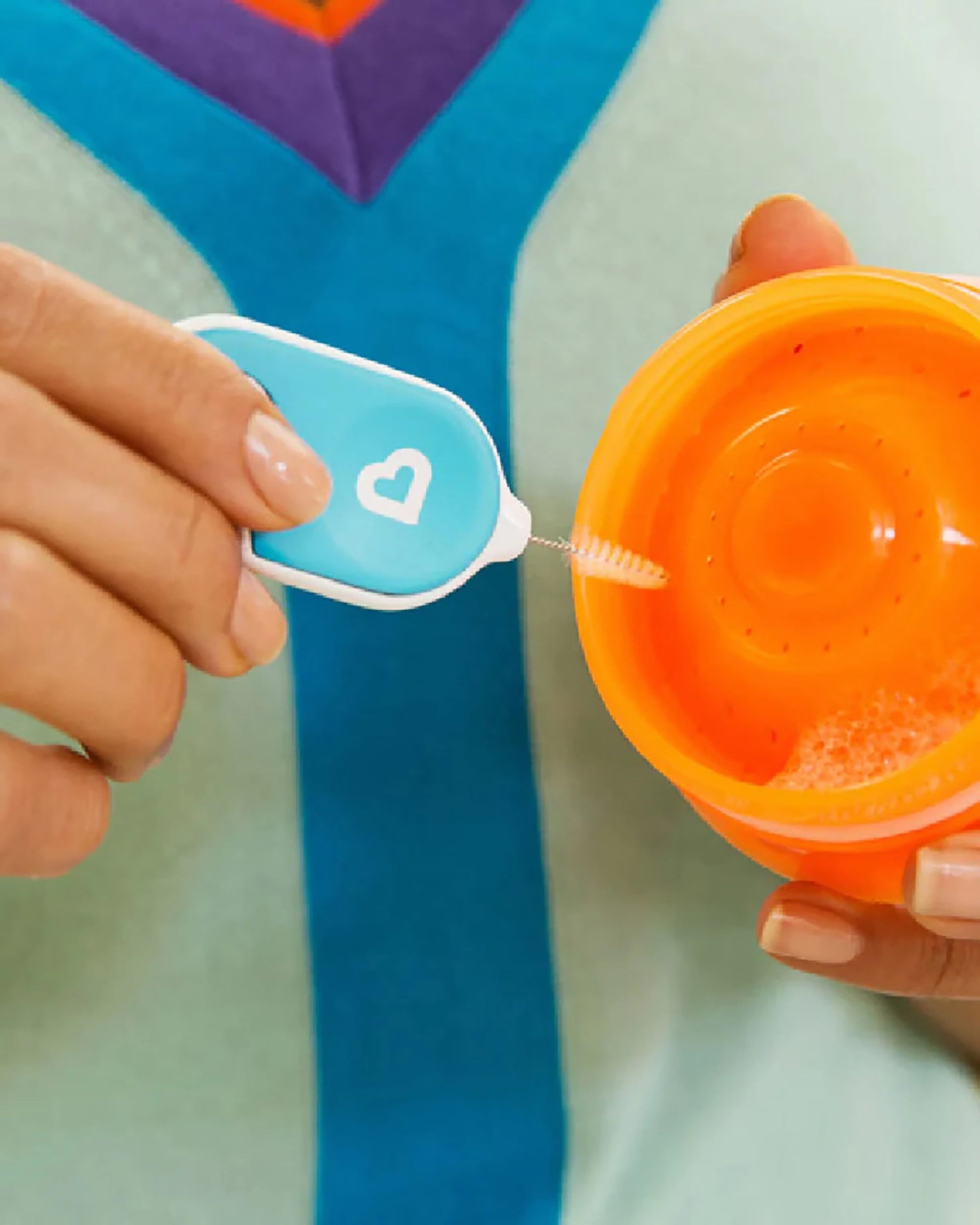 Storage ring pick on the Munchkin Details set removing a silicone sealing ring from a cup lid