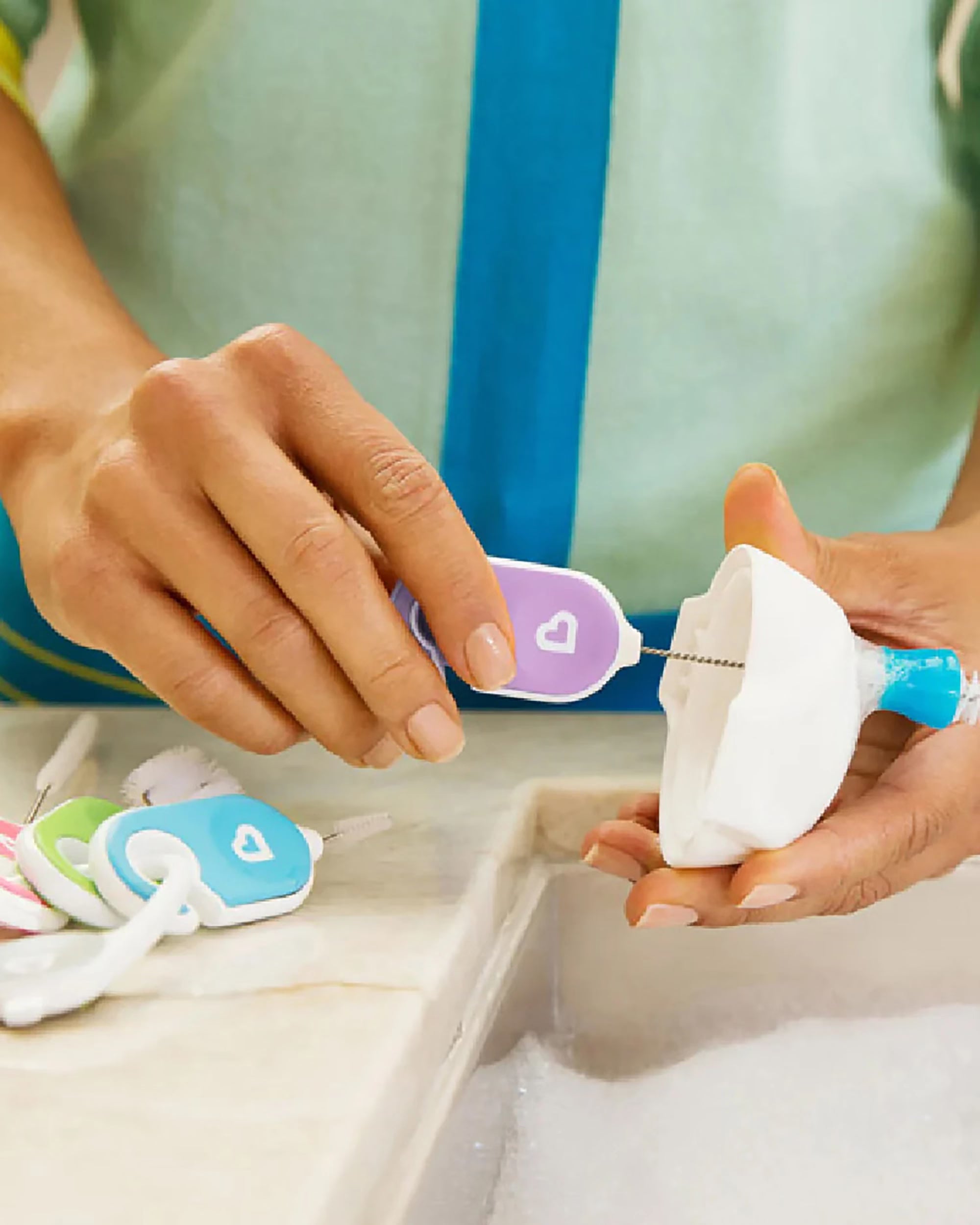 Munchkin Details brushes clipped together for storage beside the sink