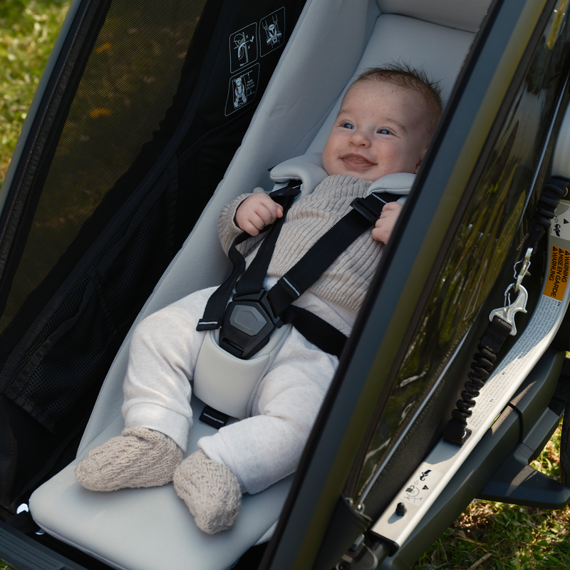 Baby secured in the Thule Chariot Infant Sling inside a Chariot trailer