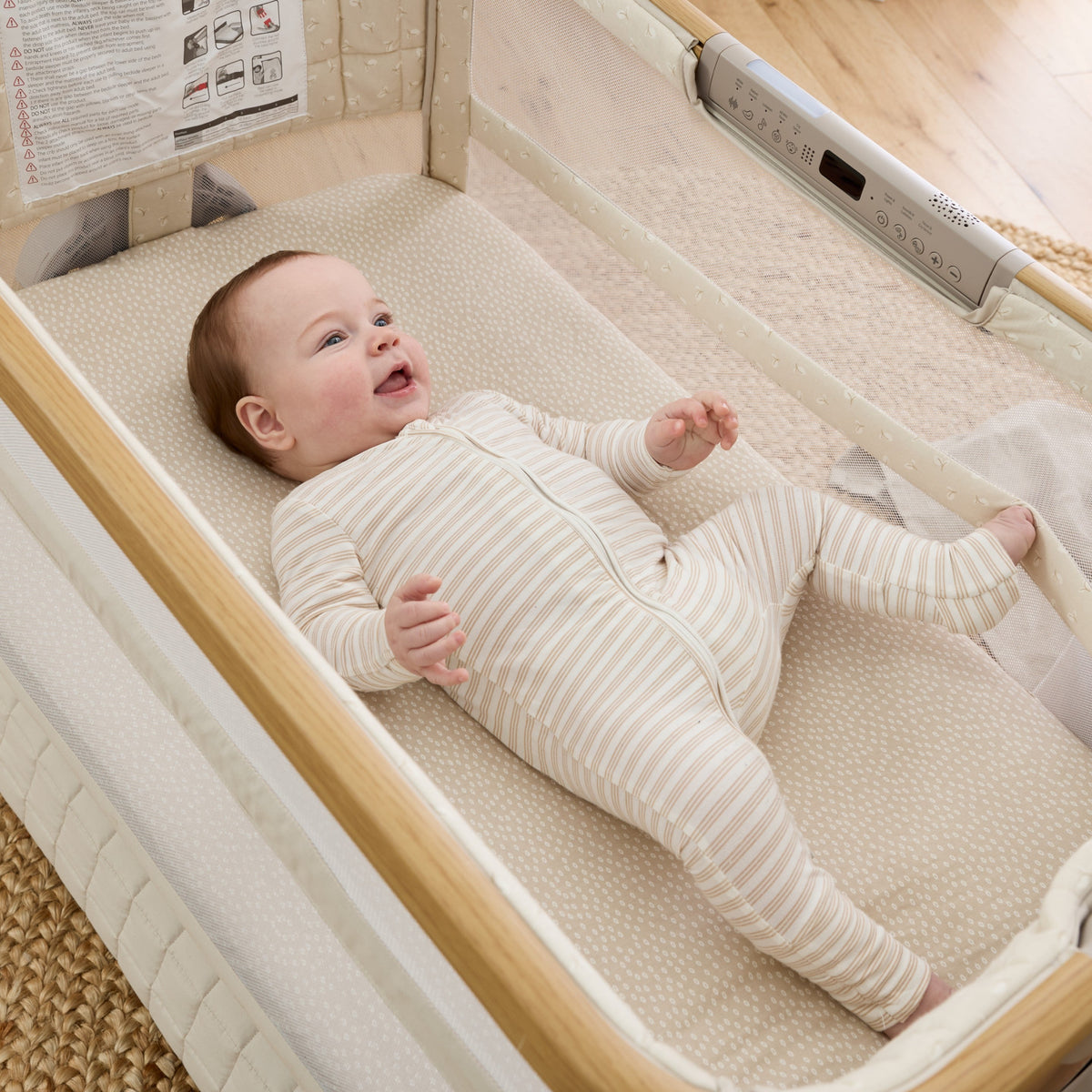Baby lying on their back in the CoZee Breeze Sense bassinet