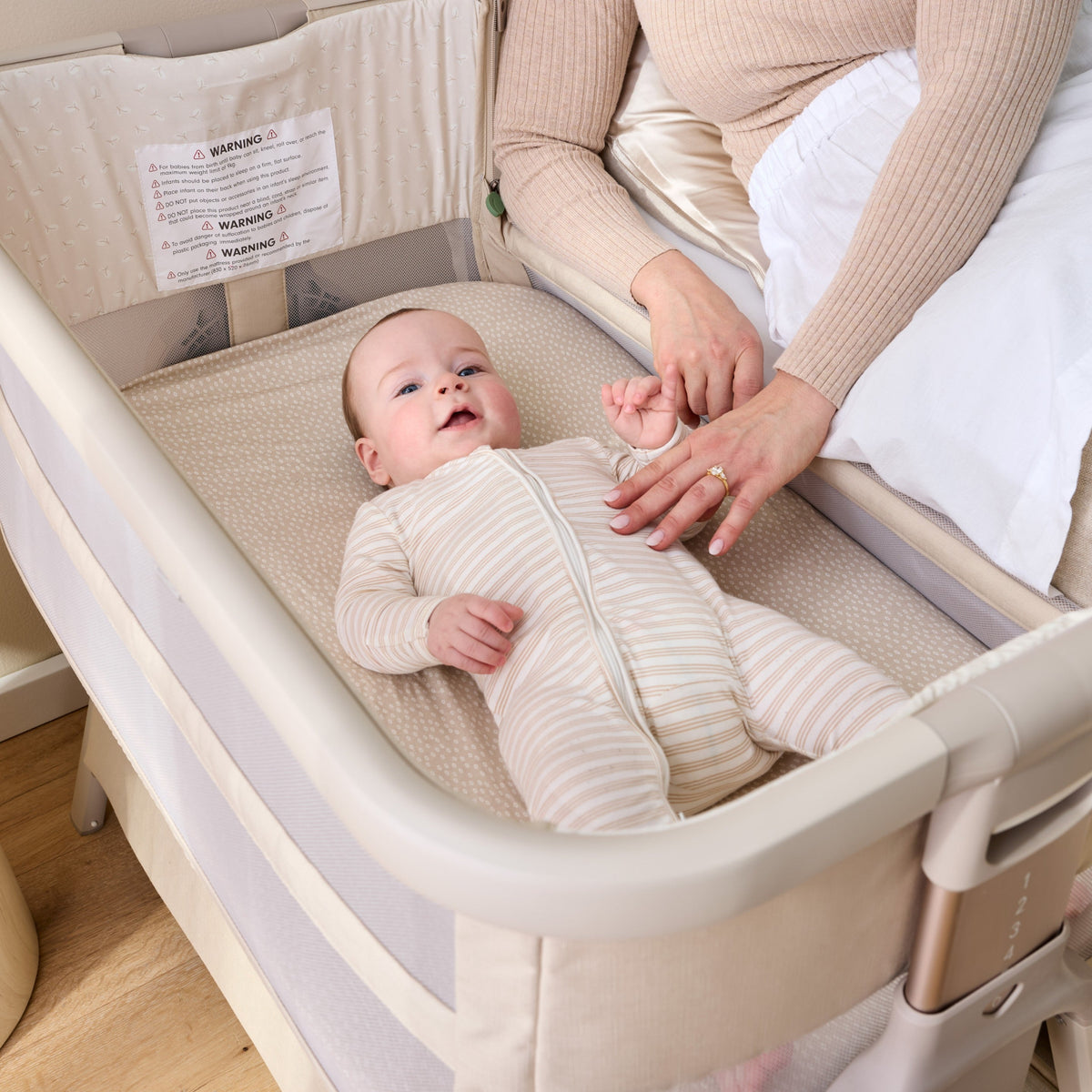 Baby lying on their back in the CoZee Breeze Zen bassinet in Sand