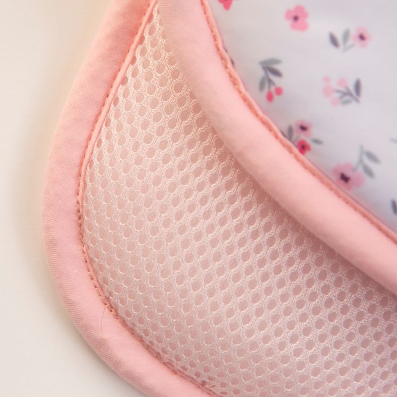 Baby sitting on the Pink Petals cooling pram liner
