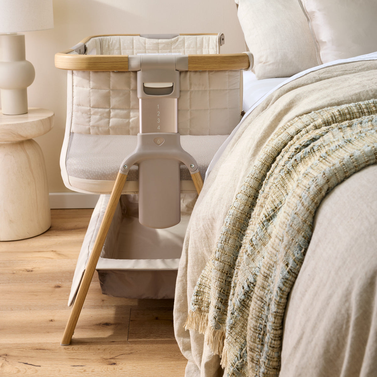 CoZee Breeze Sense attached beside the bed with the side zipped down for co-sleeping