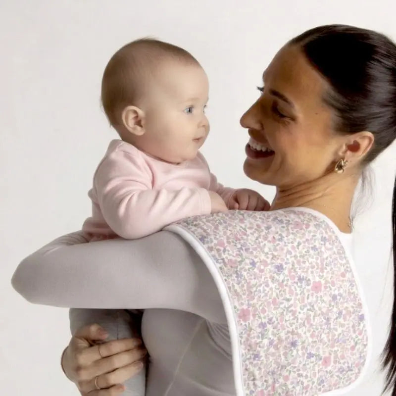 Blossom muslin burp cloth over a parent's shoulder