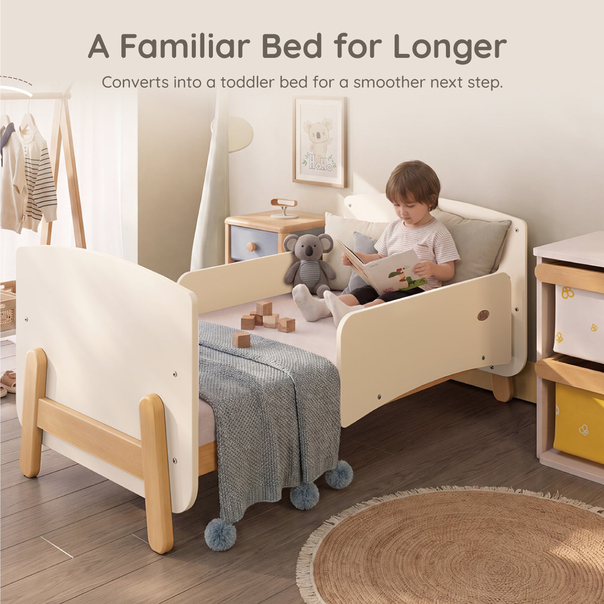 Child sitting on the Boori Natty cot converted into a toddler bed