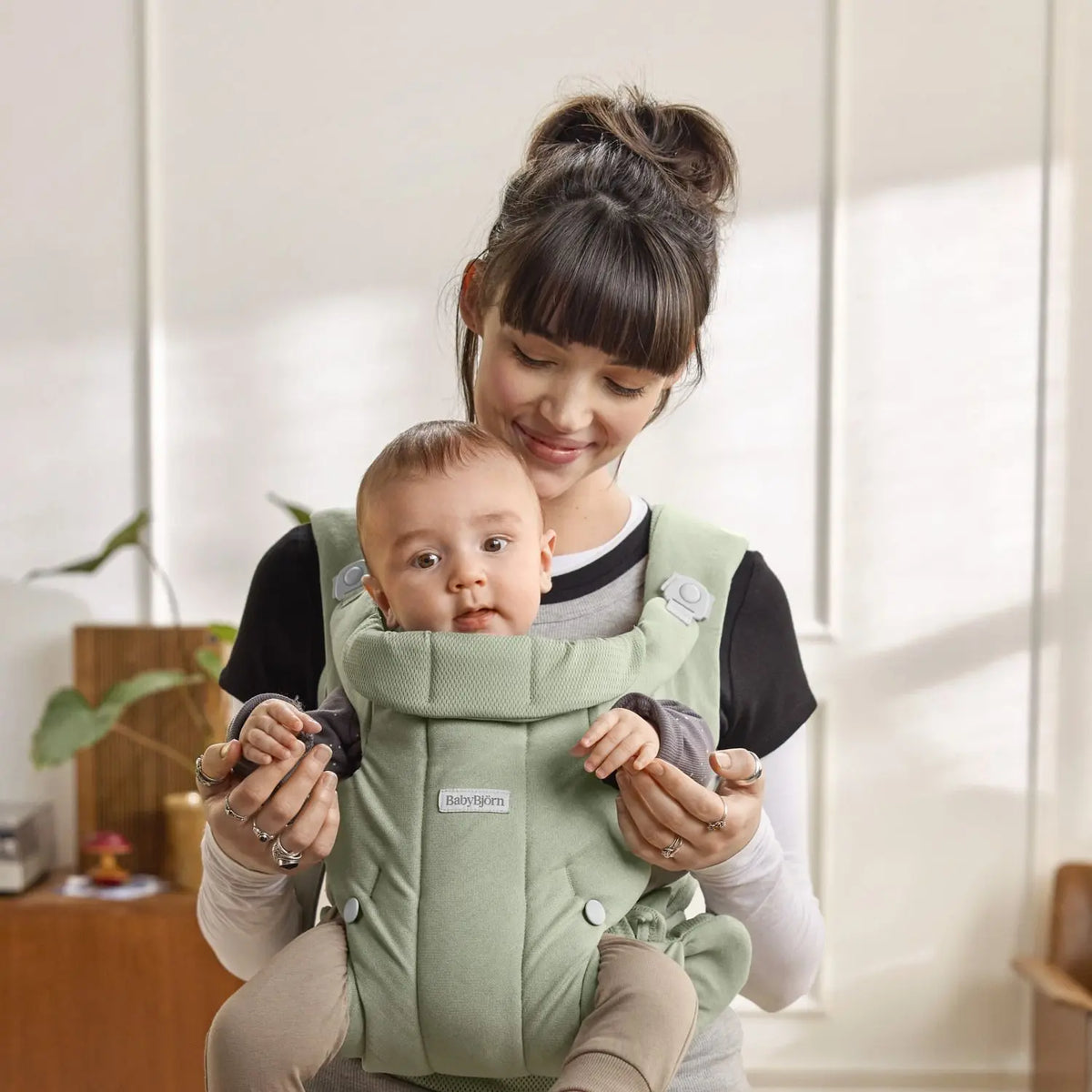 Baby facing in, snug in the BabyBjorn Baby Carrier Hold Light Green