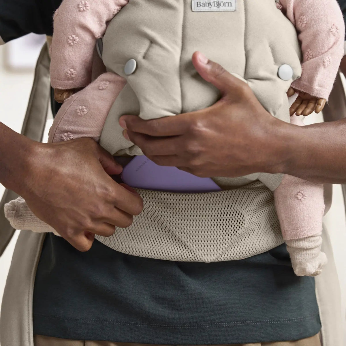Close-up of the BabyBjorn Baby Carrier Hold Sand Grey and built-in pocket