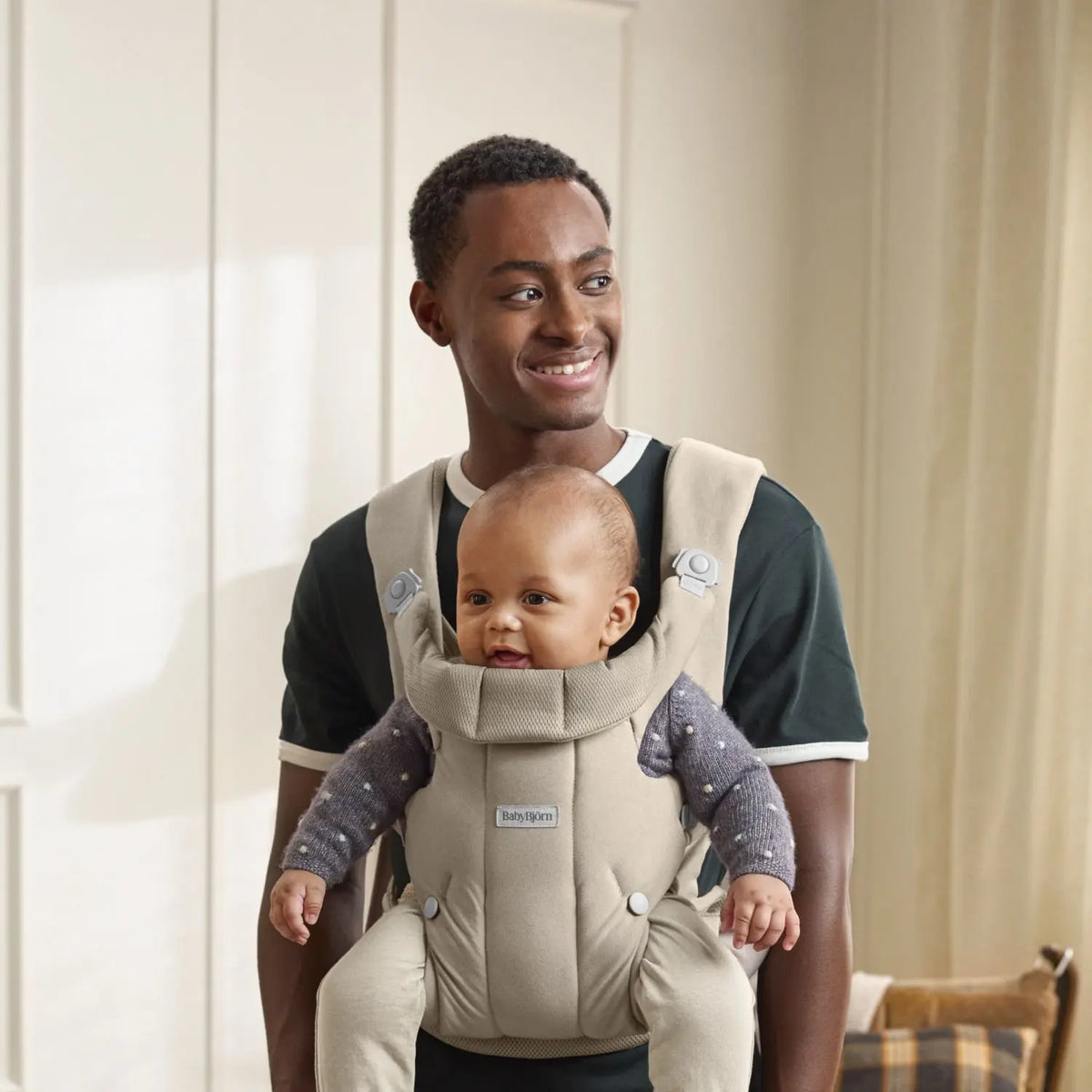 Baby facing out in the BabyBjorn Baby Carrier Hold Sand Grey