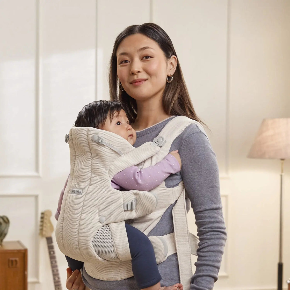 Parent wearing the BabyBjorn Baby Carrier Hold in Cream Airy Mesh