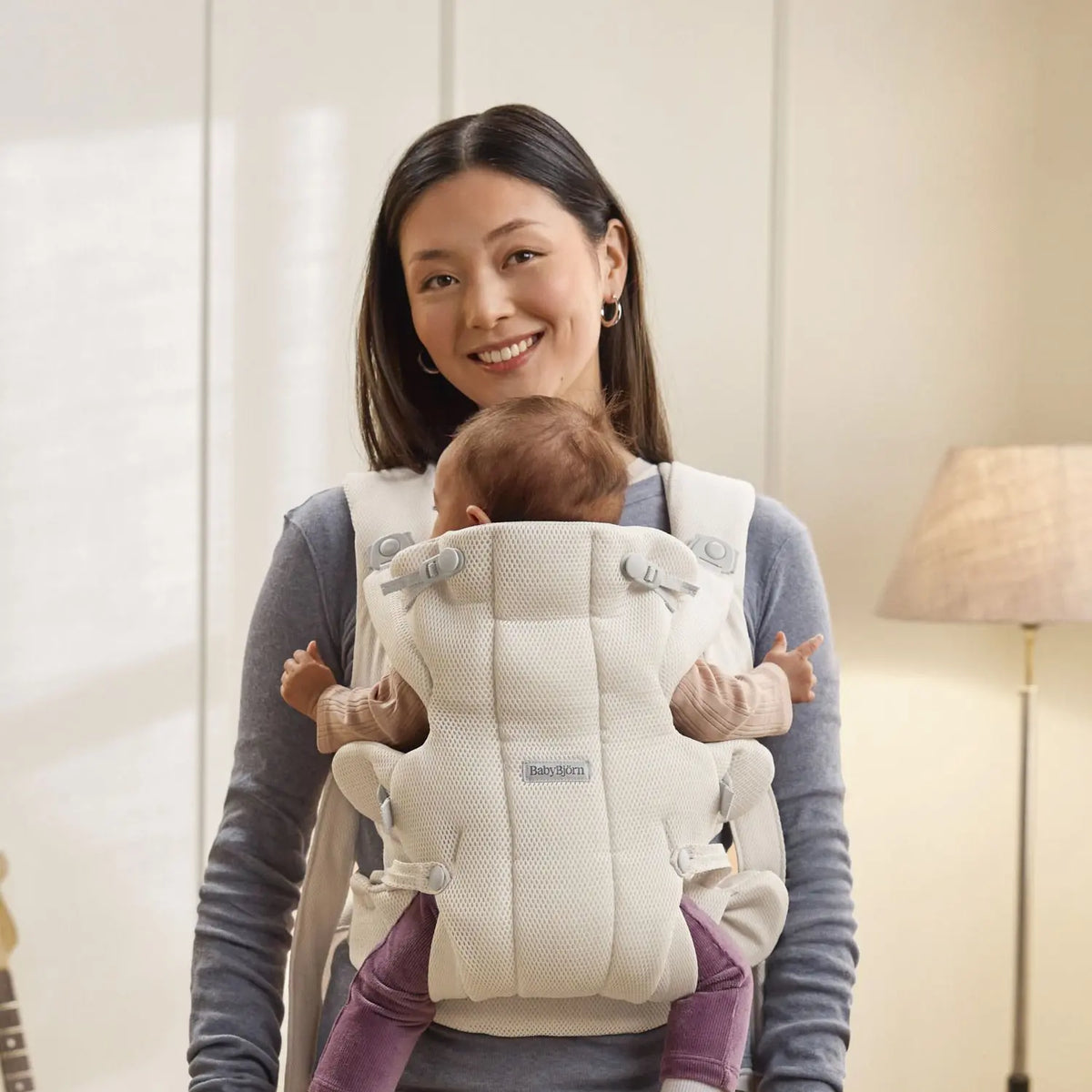 Baby facing in, snug in the BabyBjorn Baby Carrier Hold Cream