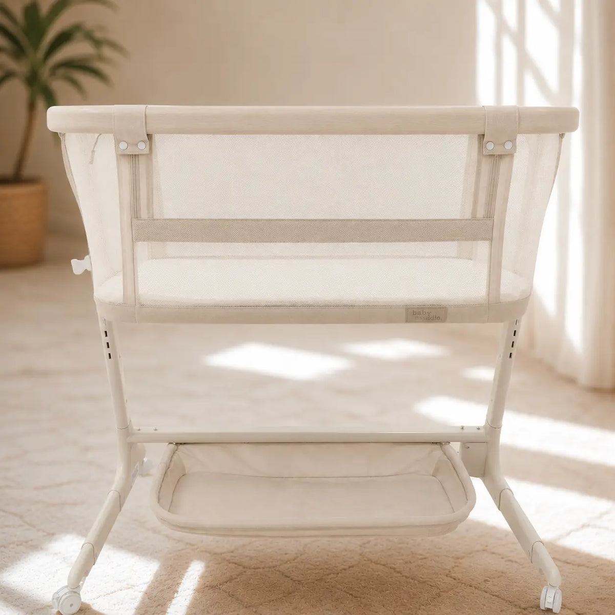 Babystudio Dream Glider bedside bassinet in Sand with the storage basket underneath