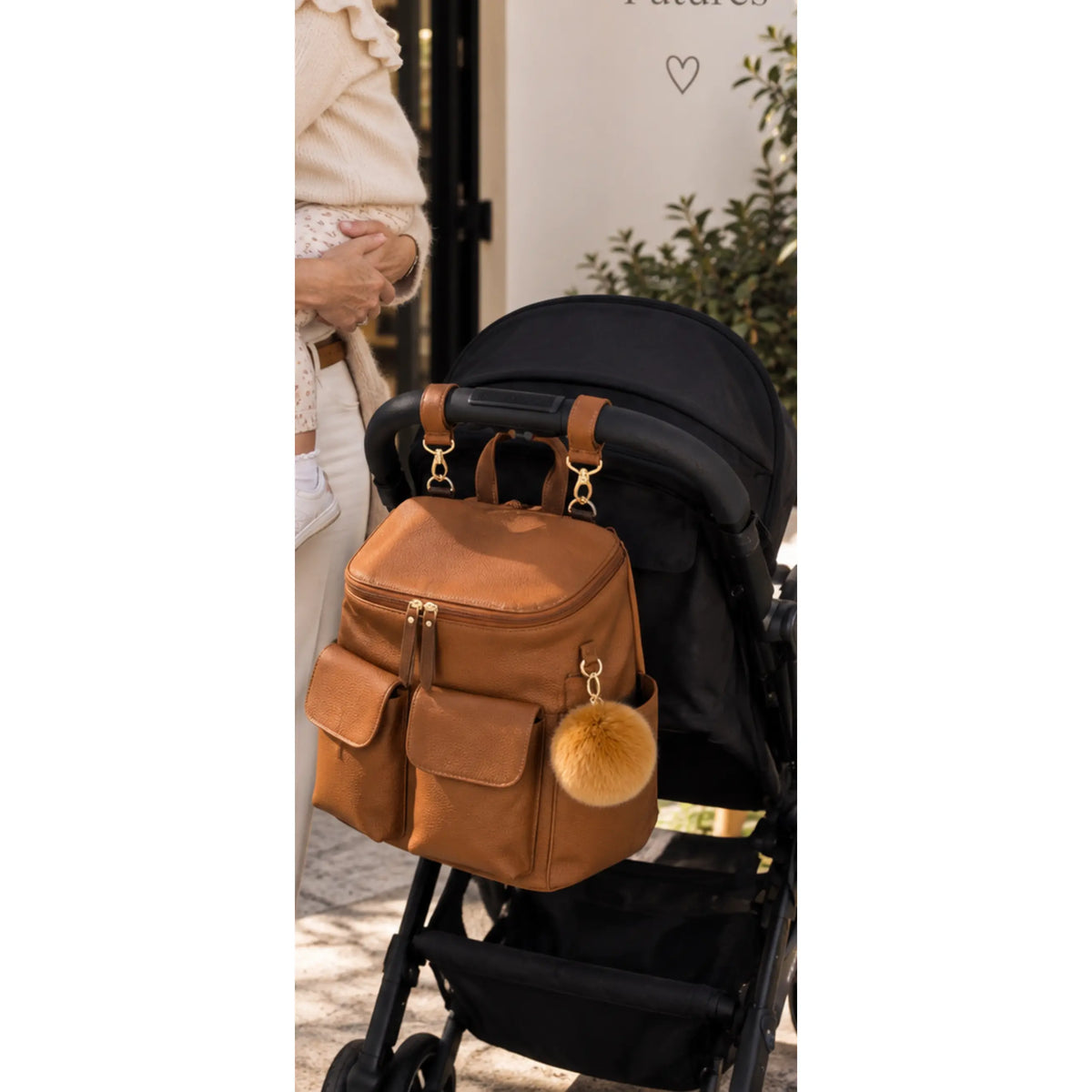 Coco Mae bag charm on the Lyon nappy backpack hanging on a pram
