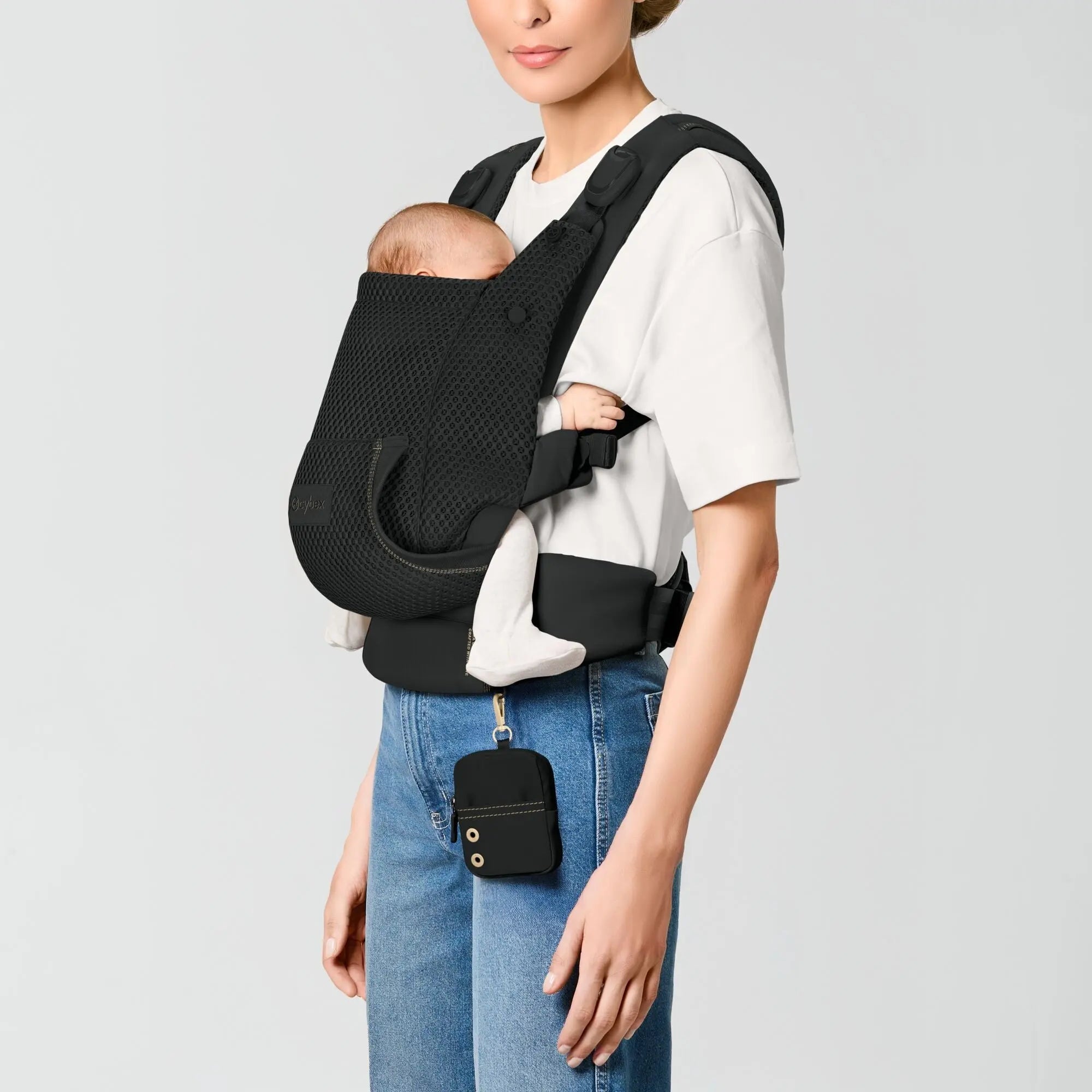 Parent carrying a newborn in the front inward position in the CYBEX Laya carrier