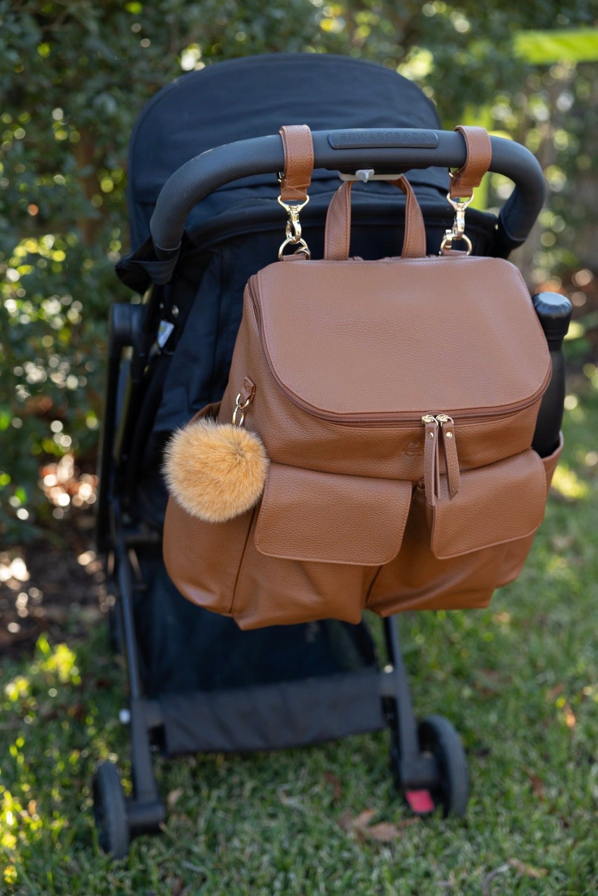 Coco Mae bag charm on a nappy backpack, lifestyle