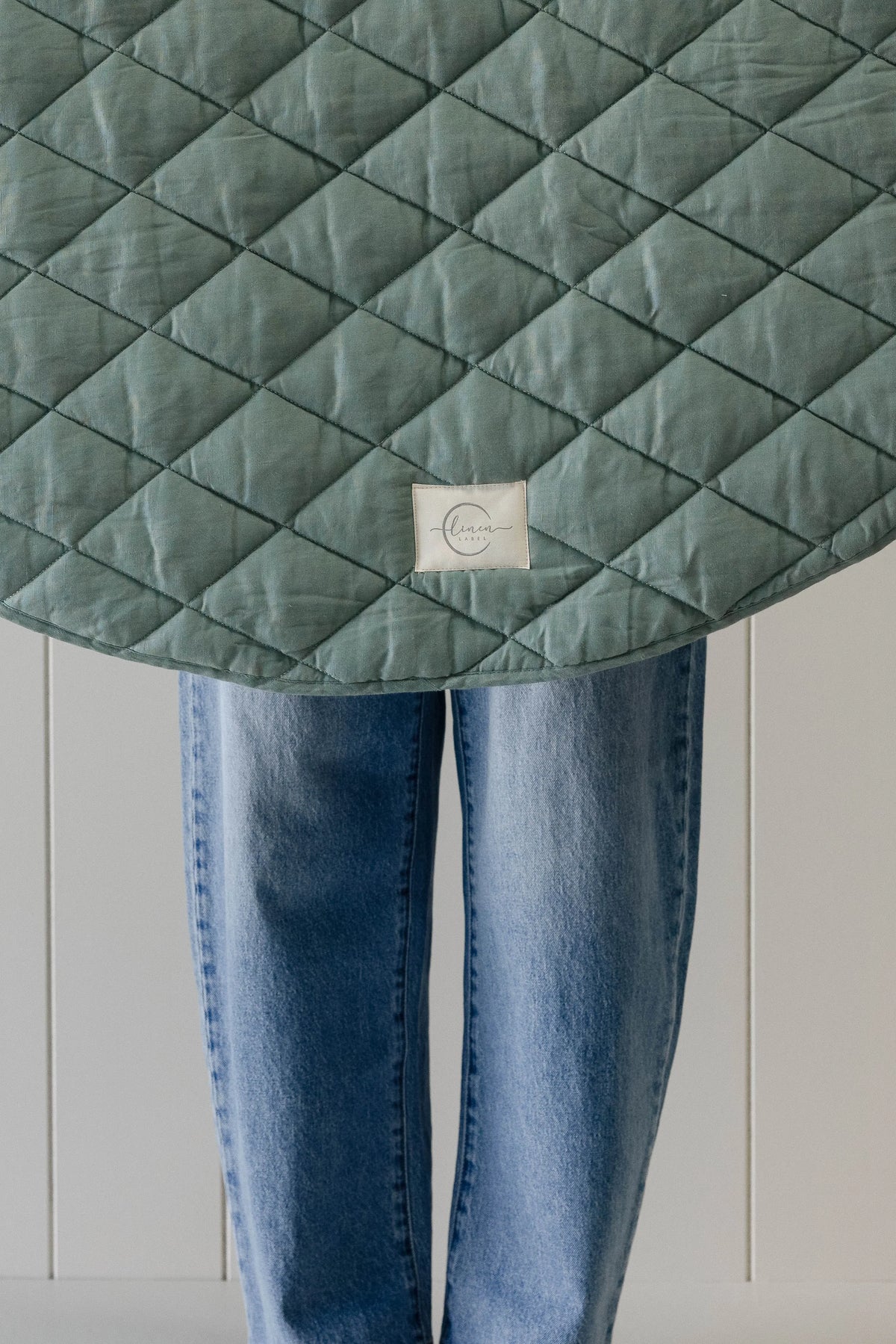Linen Label Opal Sage play mat shown in a living room