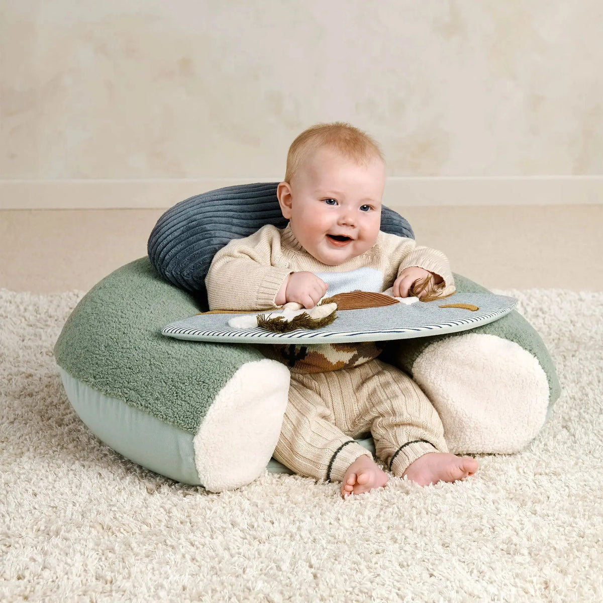 Mamas & Papas Sit & Play floor seat in Welcome to the World Pony Express, baby sitting up on the floor seat on a rug