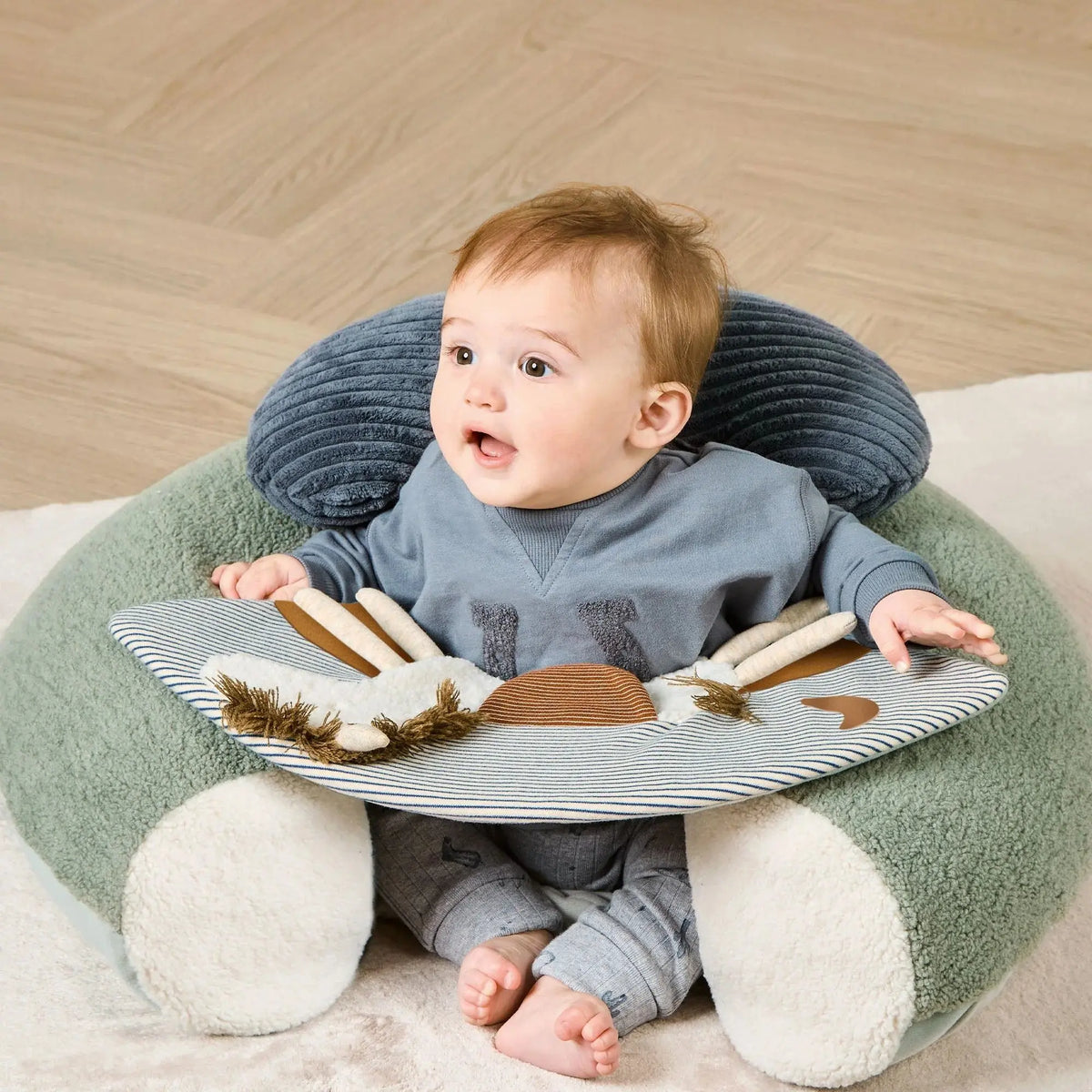 Mamas & Papas Sit & Play floor seat in Welcome to the World Pony Express, baby sitting in the seat, front view
