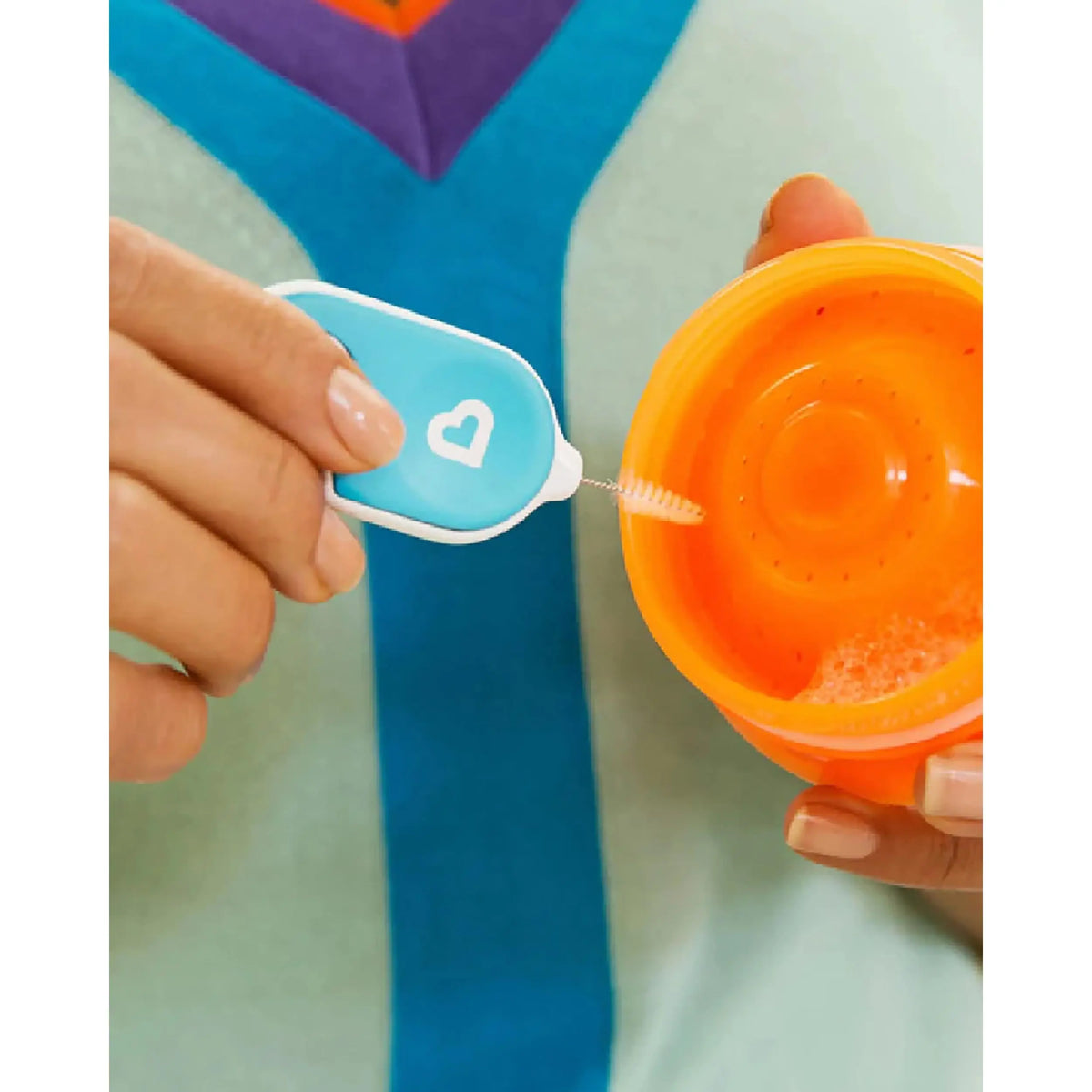 Storage ring pick on the Munchkin Details set removing a silicone sealing ring from a cup lid