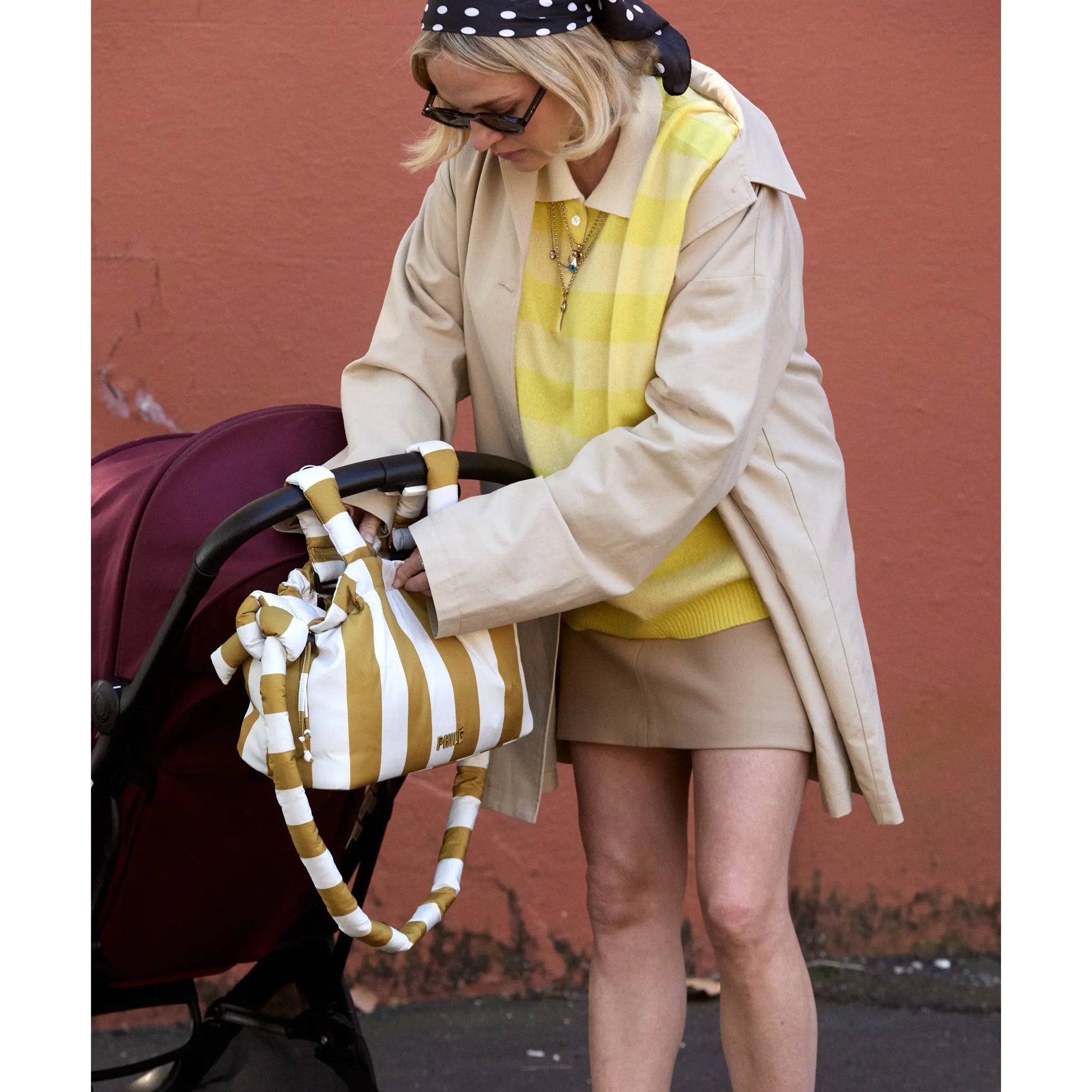 Philé Pram Caddy in Gold Stripe, lifestyle shot on pram