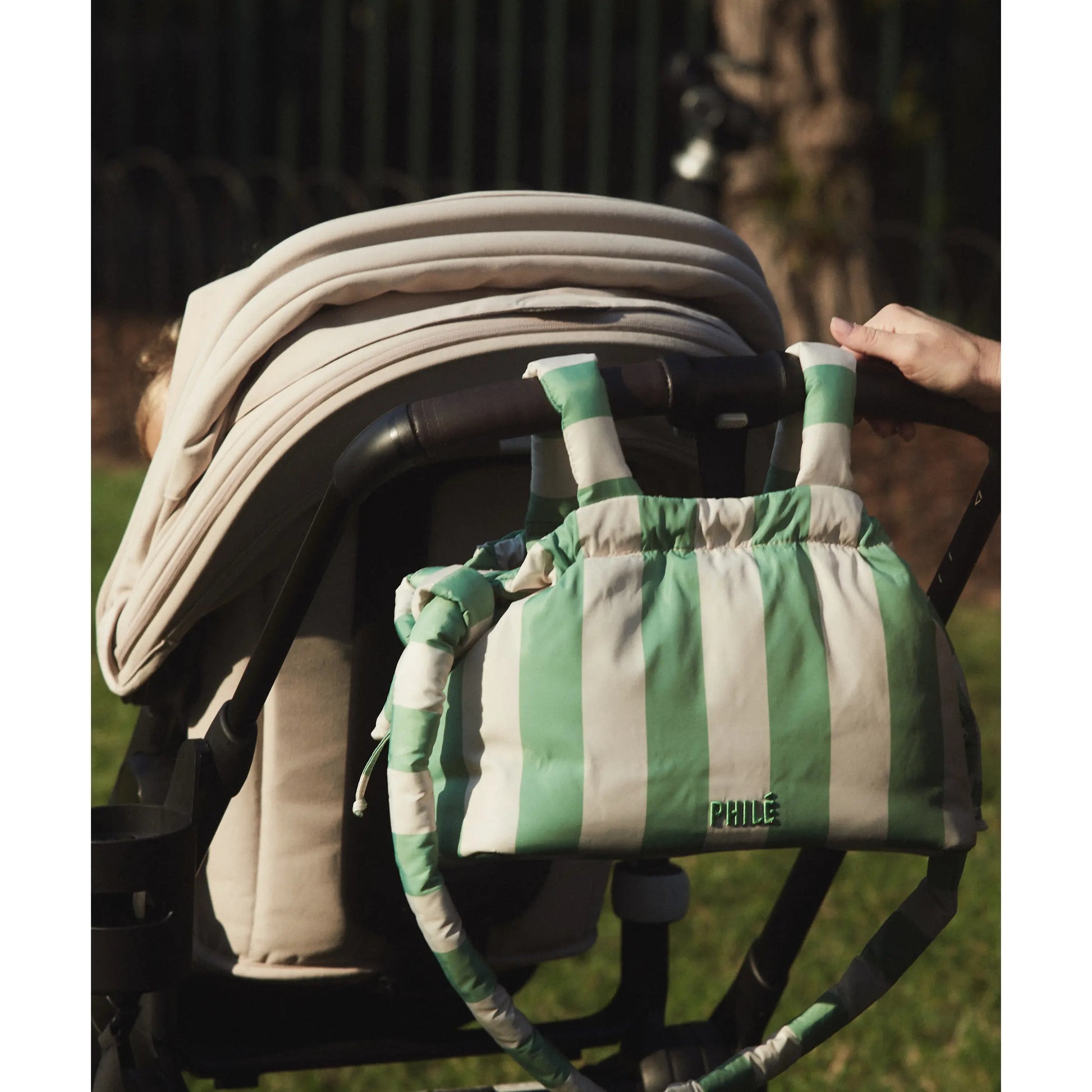 Philé Pram Caddy in Green Stripe, lifestyle shot on pram
