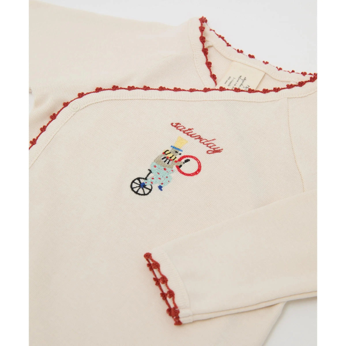 Close-up of embroidered circus character and day of the week on a Phile organic cotton bodysuit