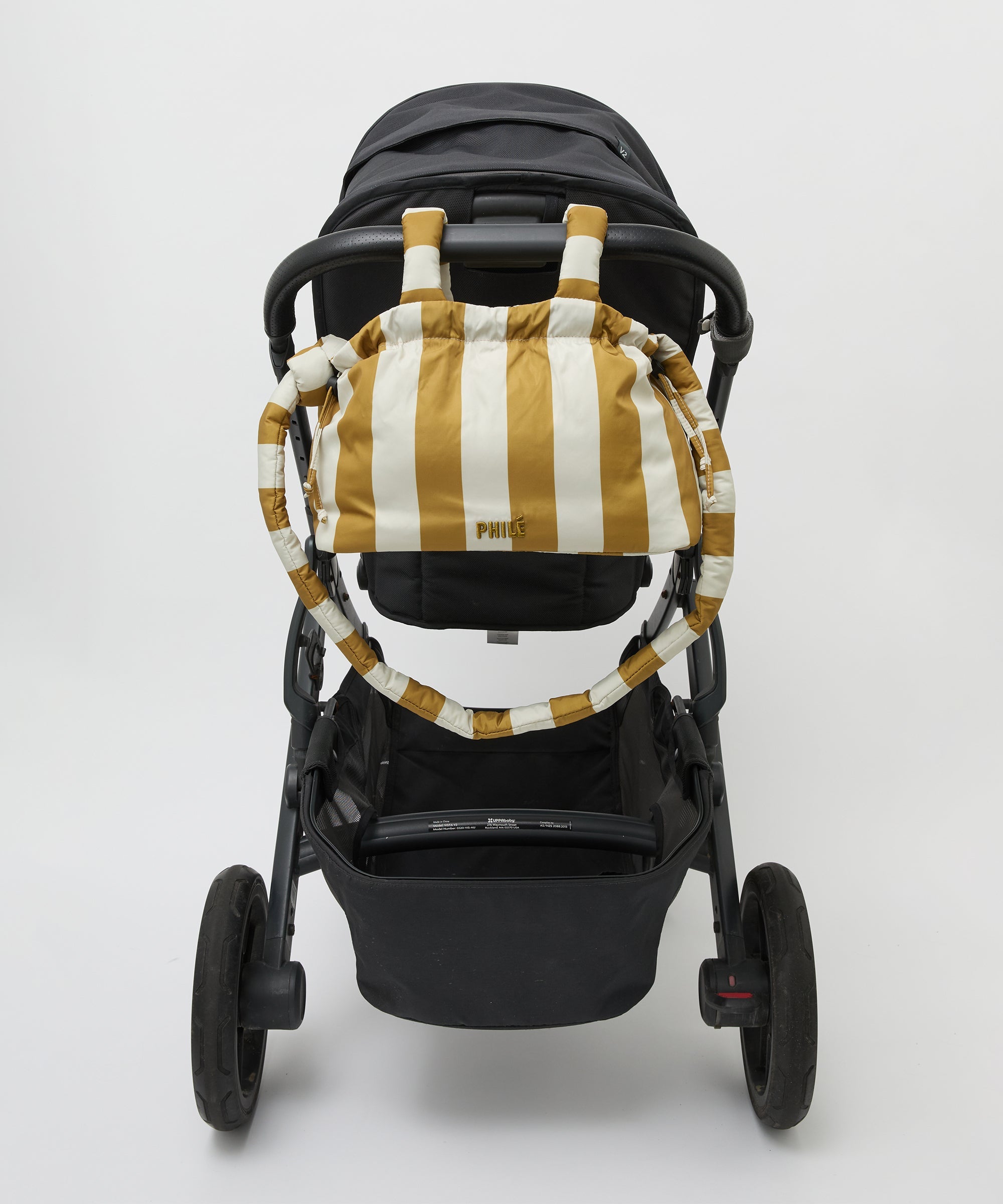 Philé Pram Caddy in Gold Stripe, worn as a crossbody bag