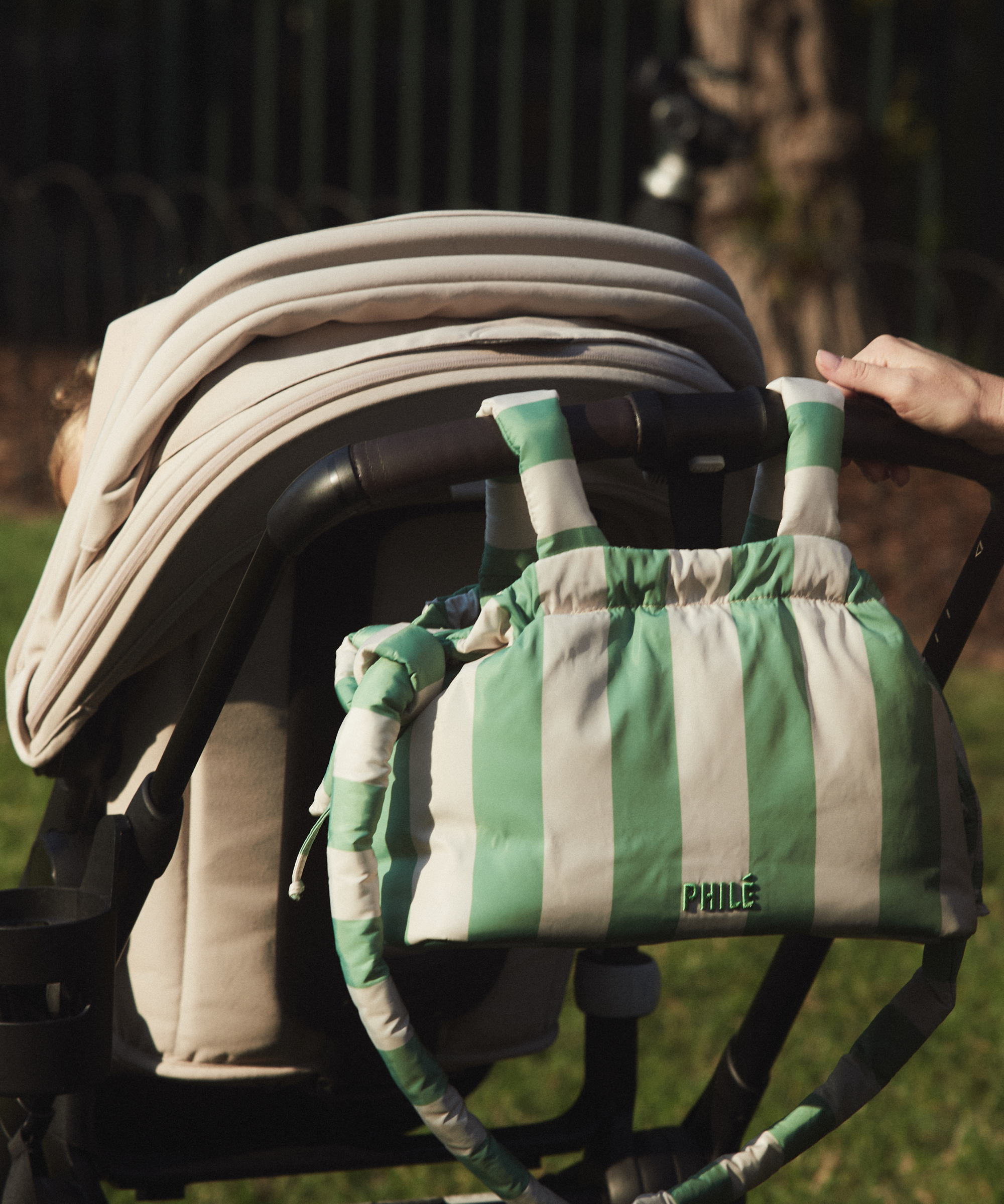 Philé Pram Caddy in Green Stripe, lifestyle shot on pram