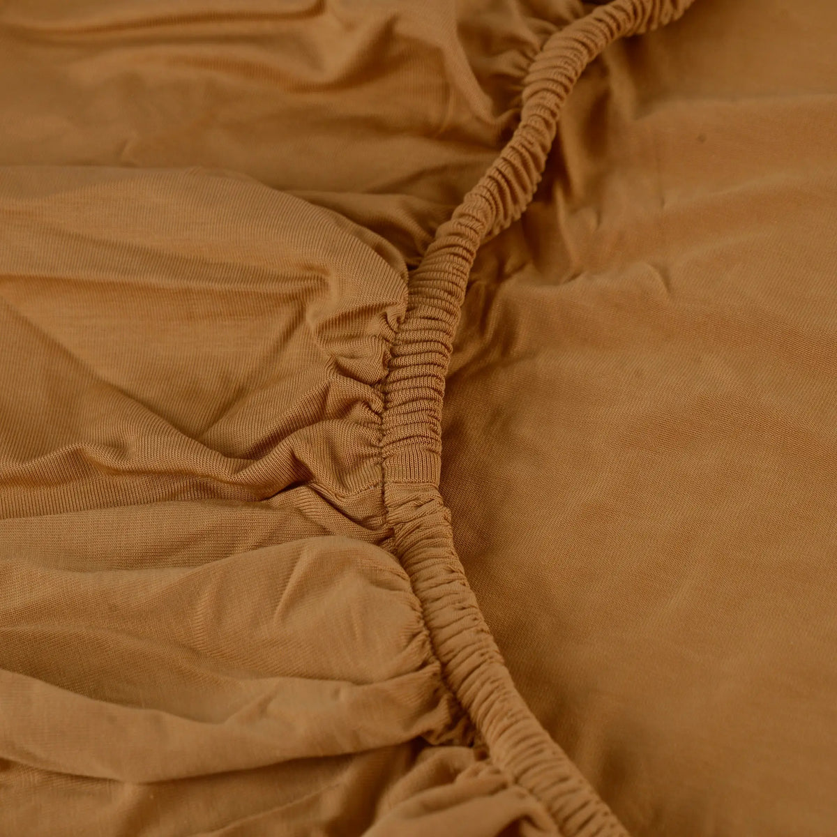 Seena cot fitted sheet in Burnt Caramel, elastic corner detail