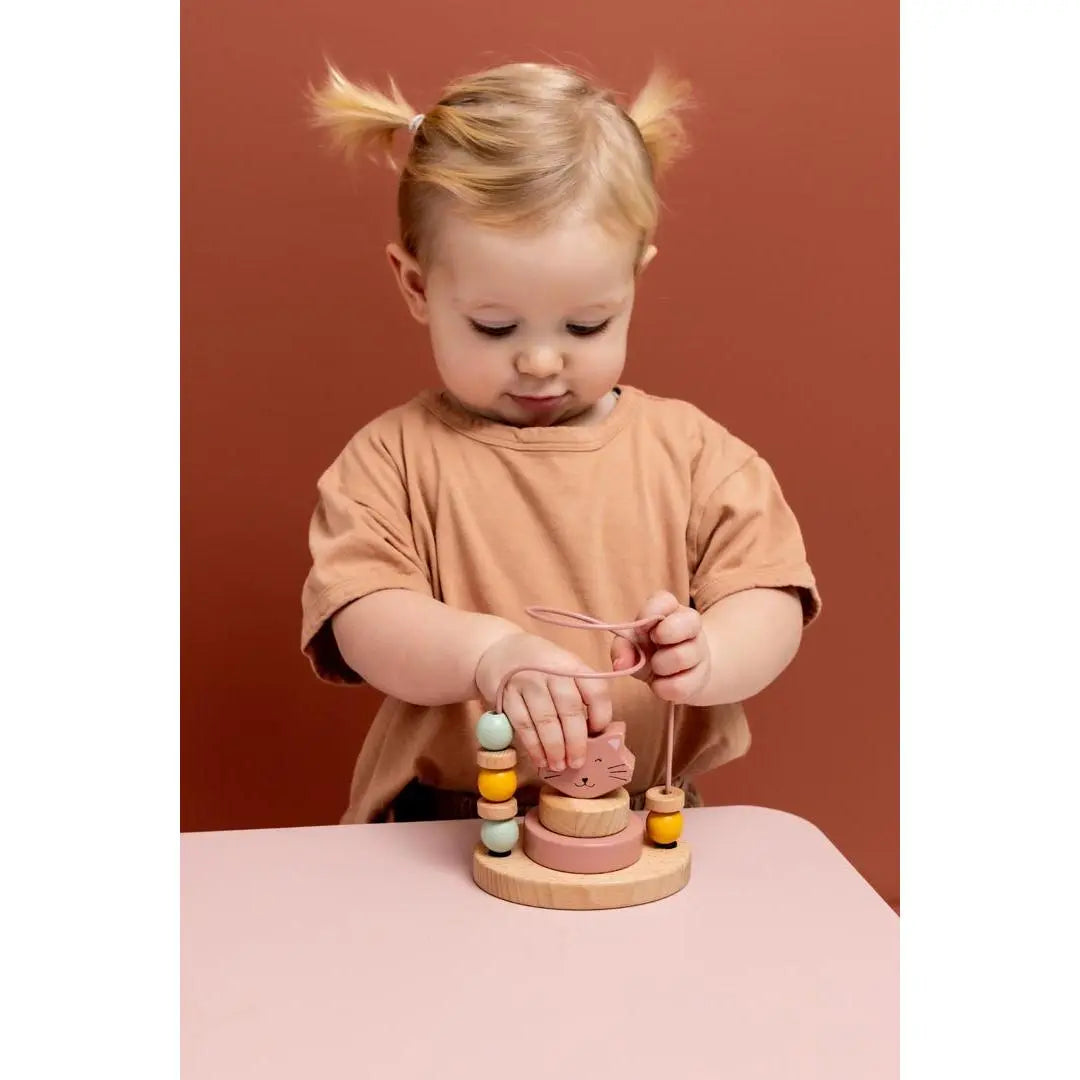 Toddler hand sliding beads on Trixie Mrs. Cat fine motor maze toy