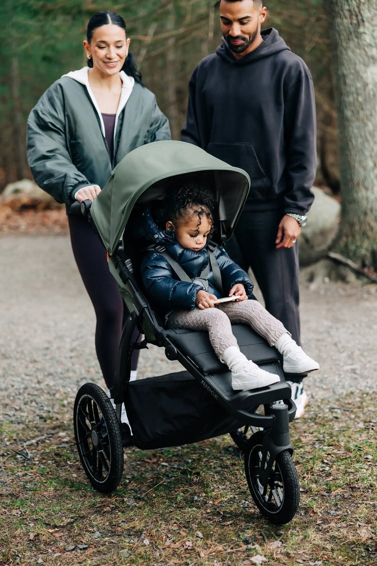 Family out walking a trail with a toddler in the UPPAbaby Ridge V2, Evelyn (Meadow Green)