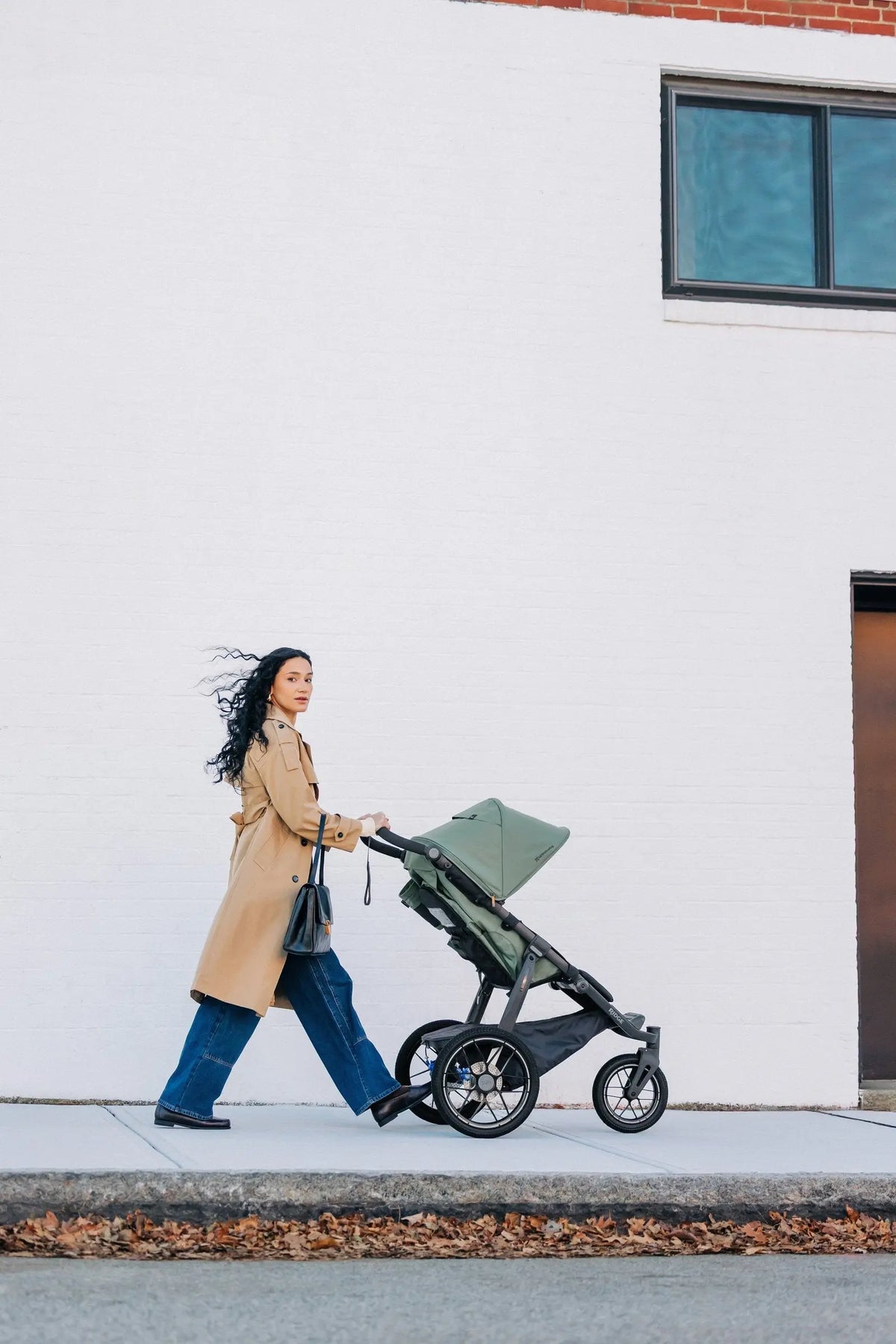 Pushing the UPPAbaby Ridge V2 in Evelyn (Meadow Green) along a city footpath