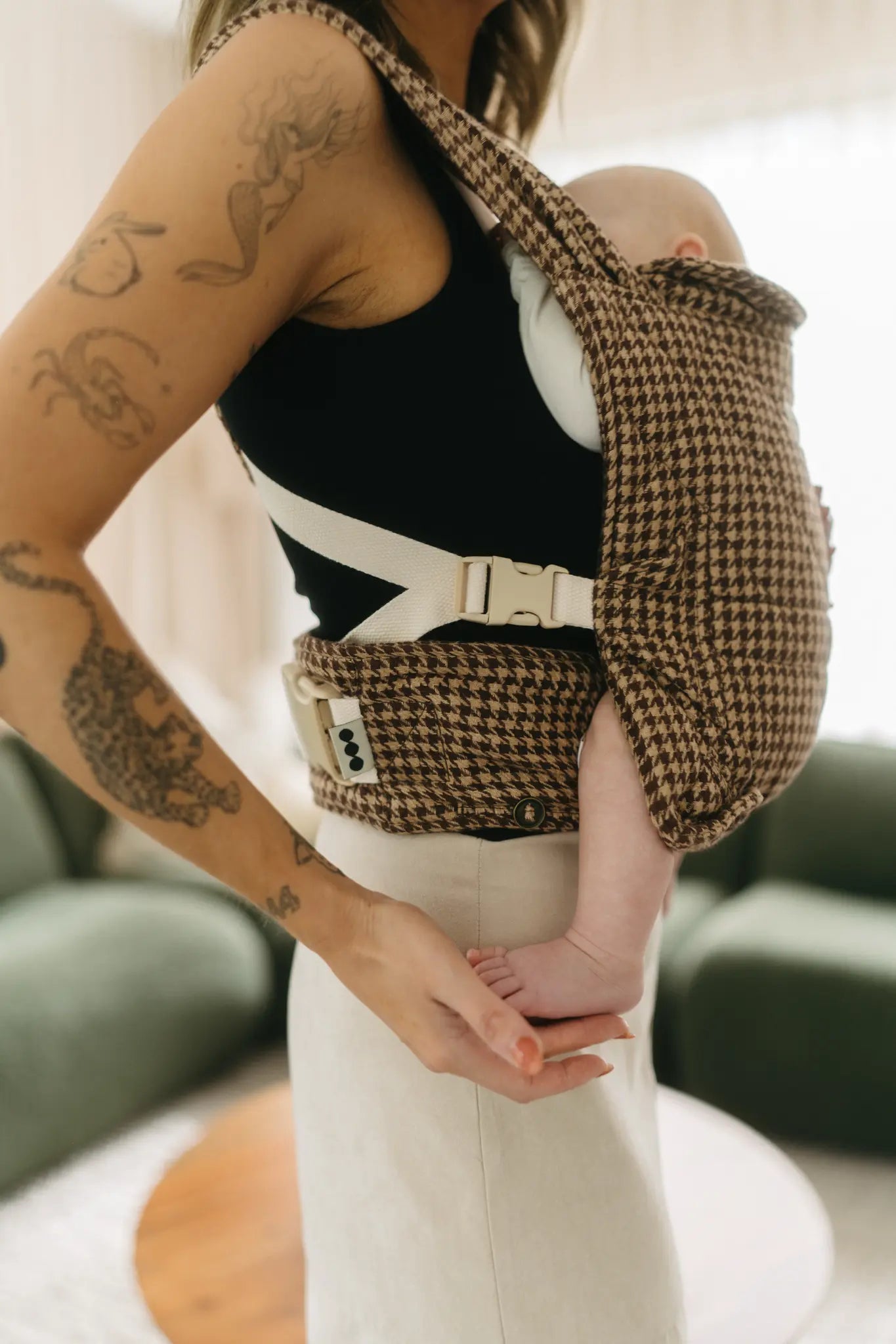 Parent wearing newborn in the Arista houndstooth Daily Carrier, front carry