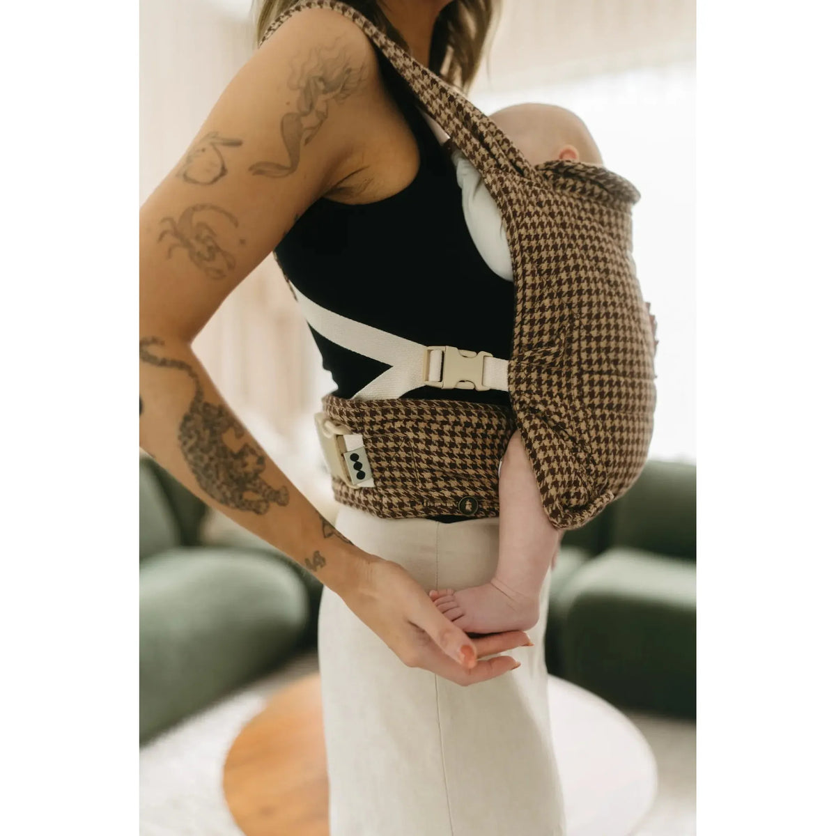 Parent wearing newborn in the Arista houndstooth Daily Carrier, front carry