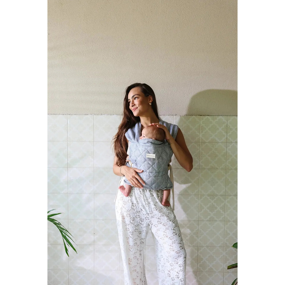 Close-up of newborn settled in the Lane Daily Carrier quilted bodice