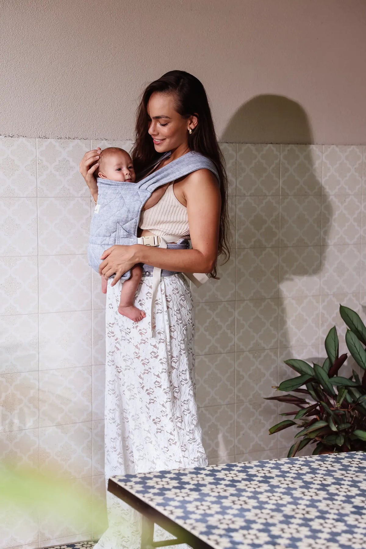 Parent wearing newborn in the Lane herringbone Daily Carrier, front carry