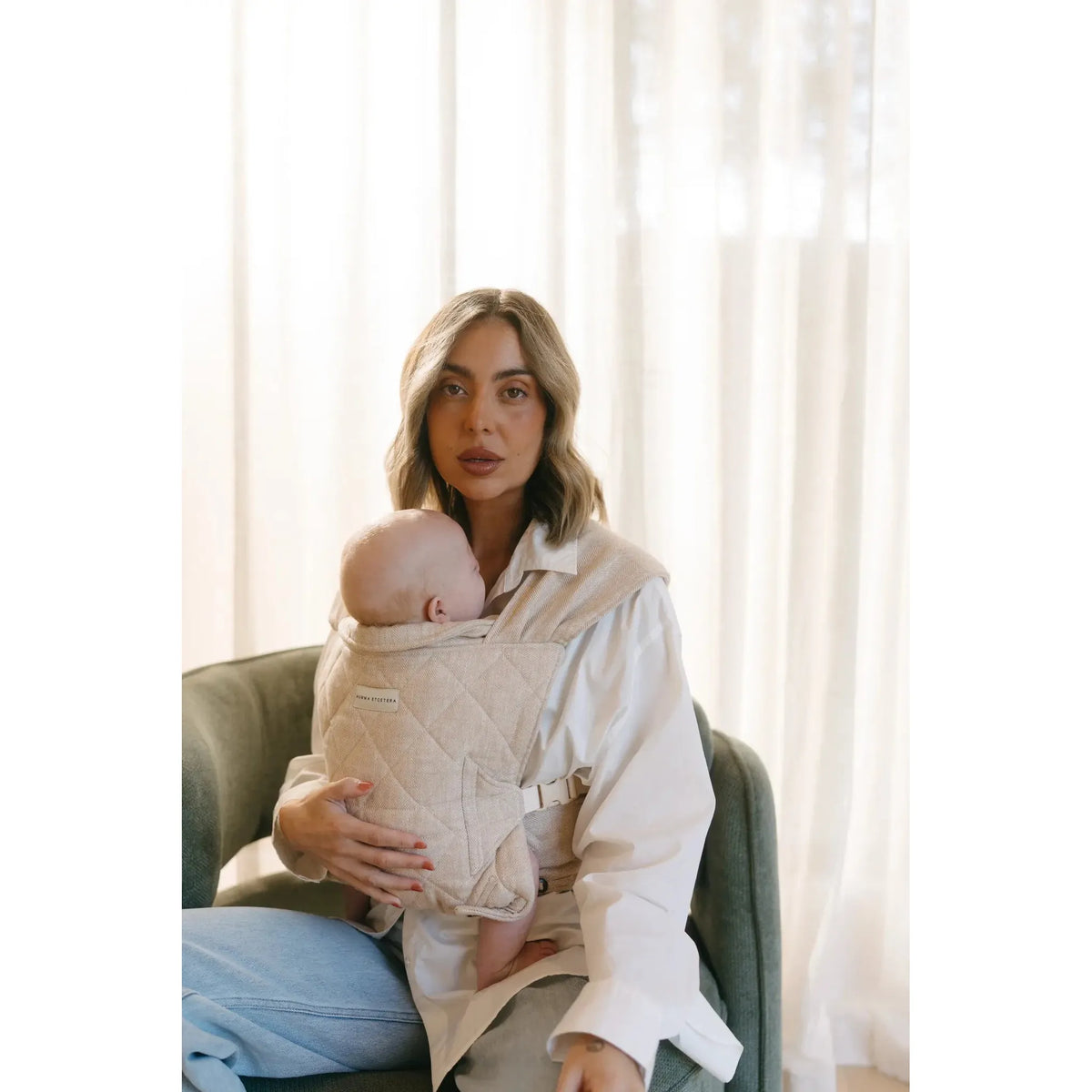 Newborn carried in the Meadow Mumma Etcetera Daily Carrier, front inward-facing
