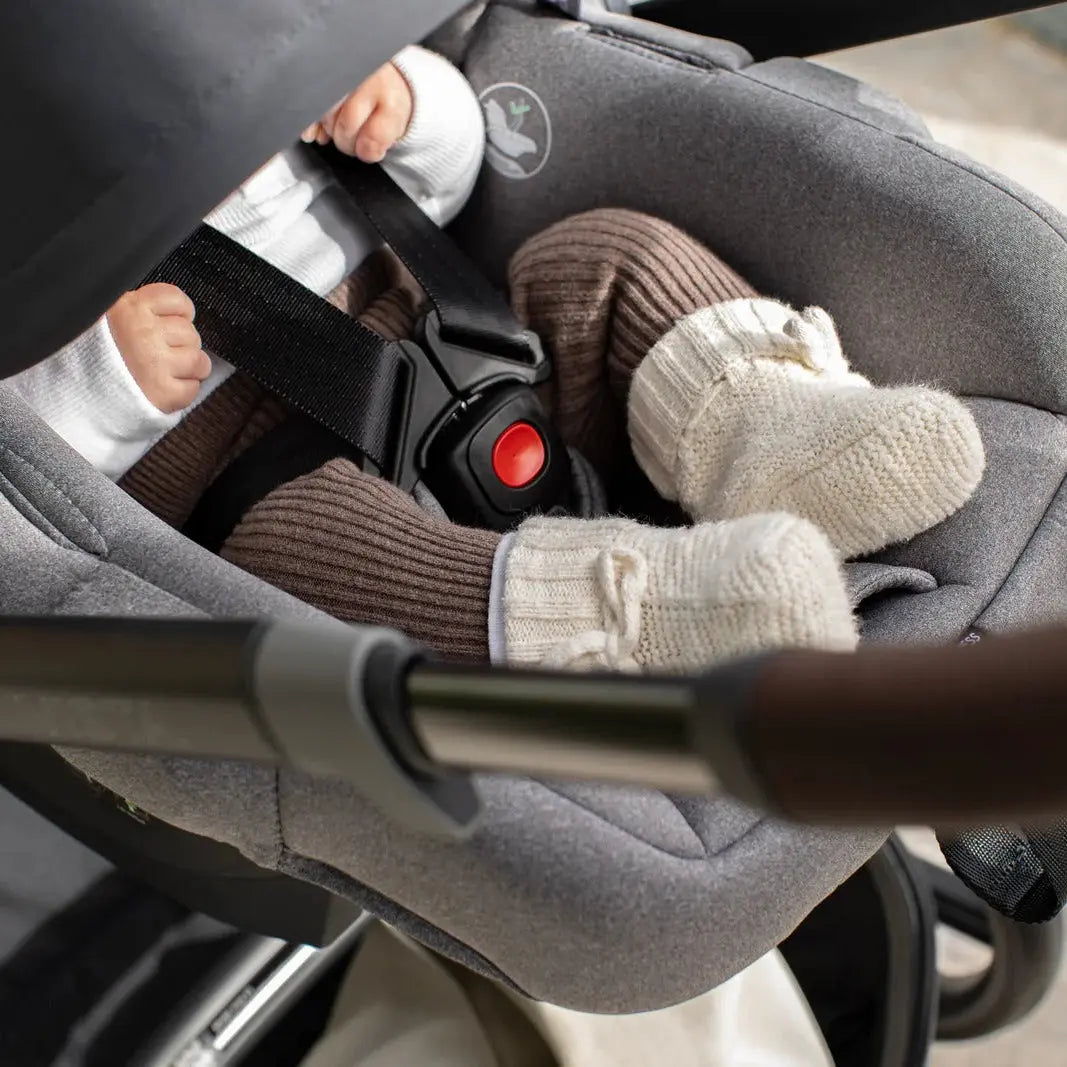 Child in a stroller wearing mittens with a blurred background
