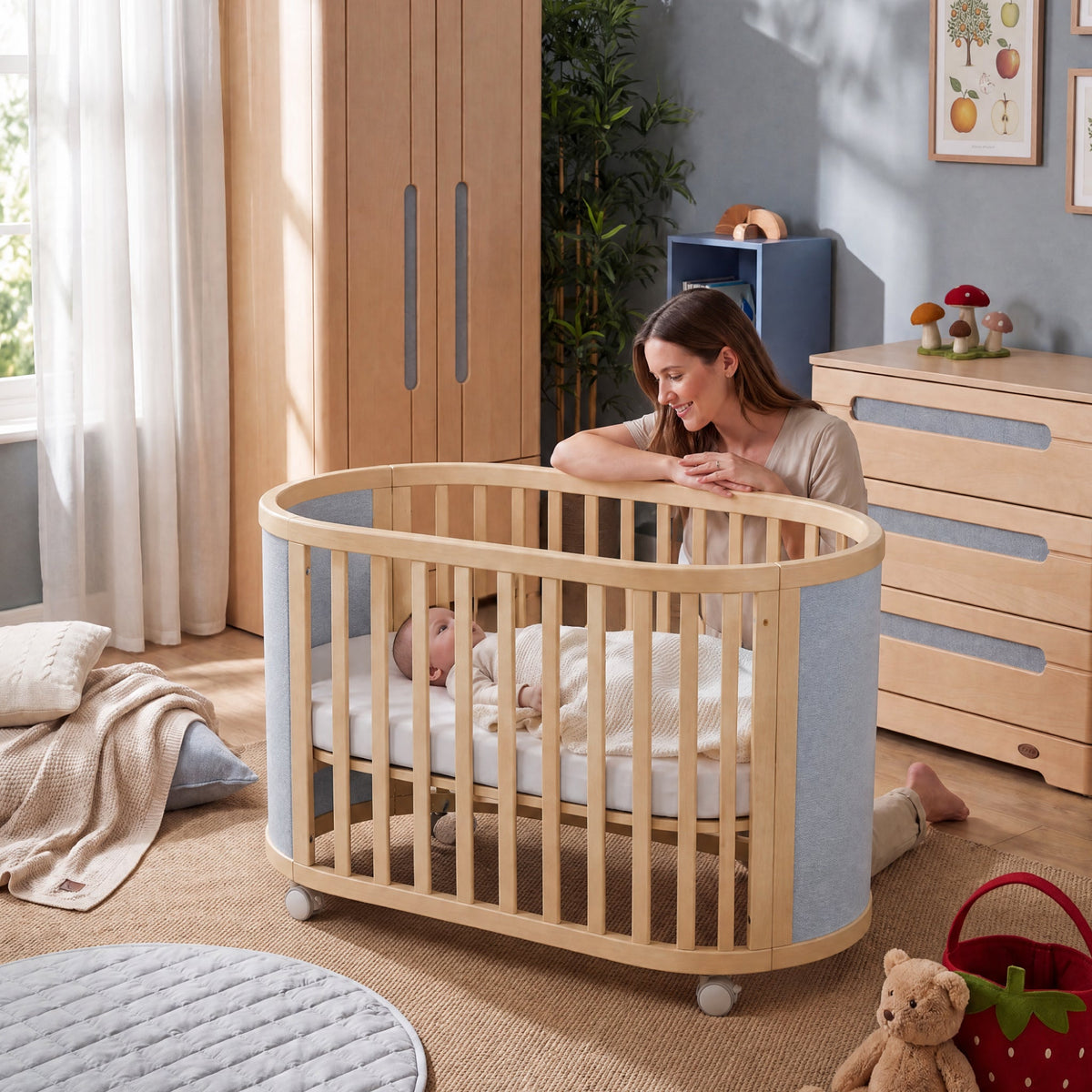 Eden Elite Oval Cot in a nursery with quiet castors (shown in Light Blueberry & Beech)