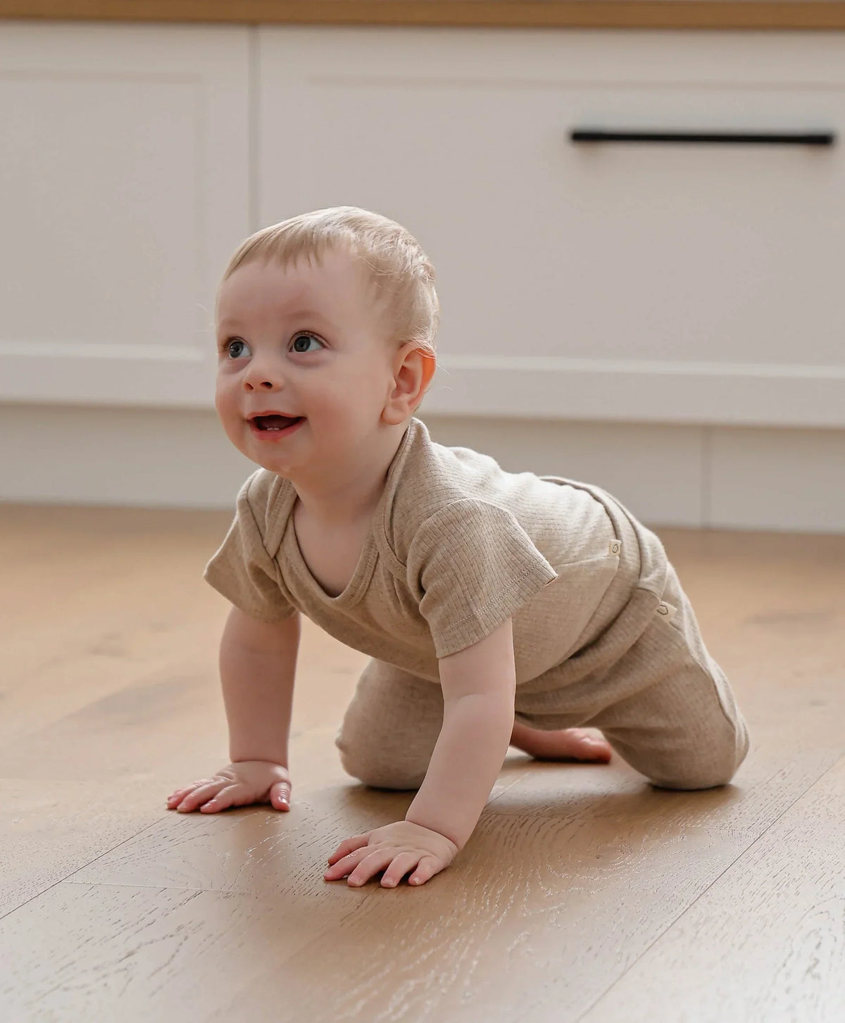 Lummi in Colour Heather Oat bodysuit worn by a baby