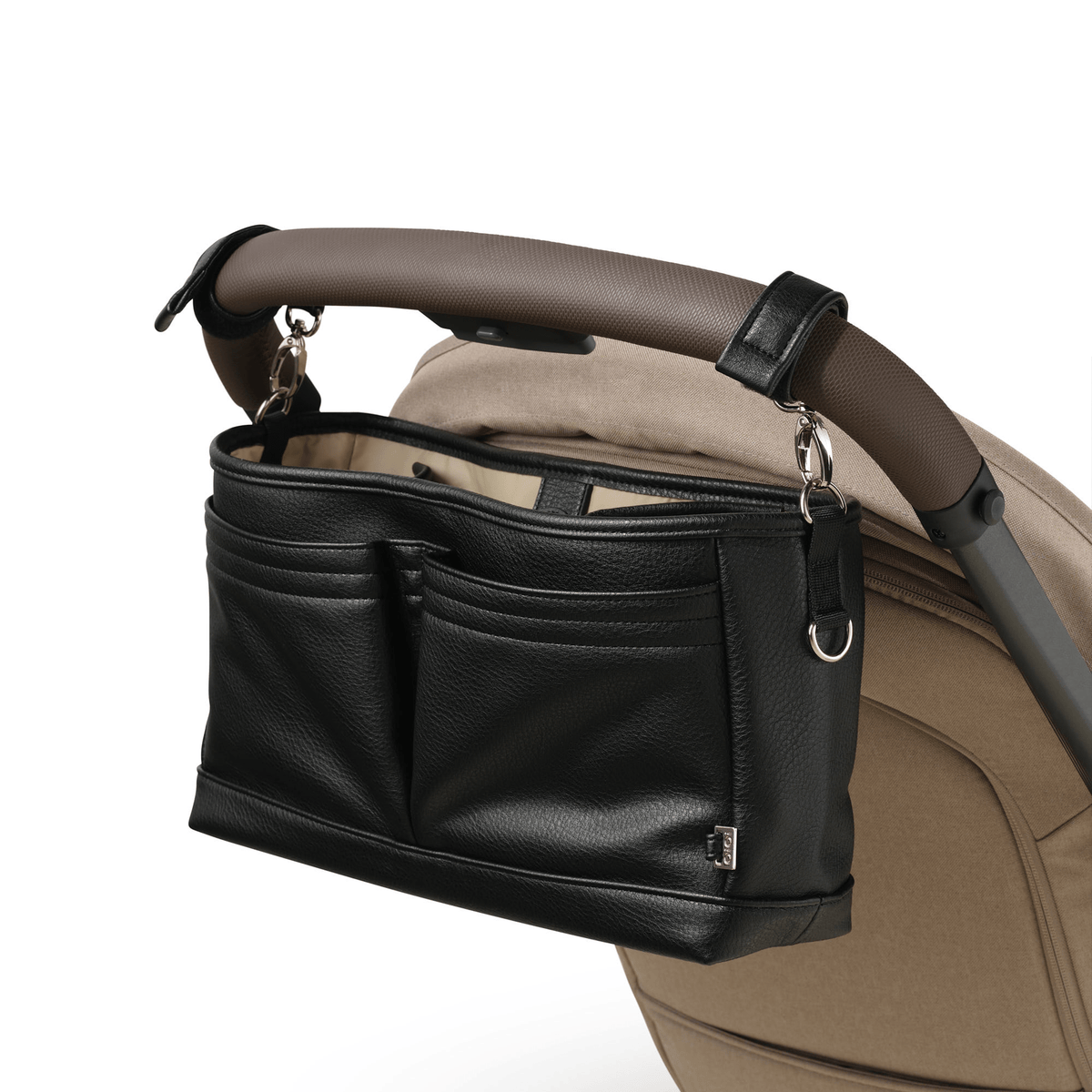 OiOi Signature Pram Caddy in black dimple vegan leather attached to a pram handlebar