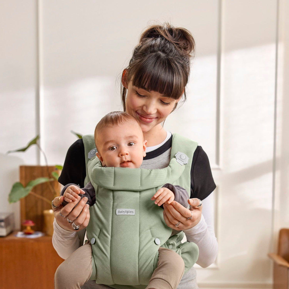 Baby facing in, snug in the BabyBjorn Baby Carrier Hold Light Green