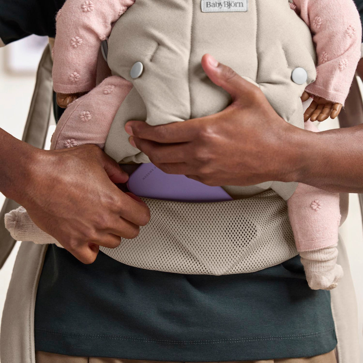 Close-up of the BabyBjorn Baby Carrier Hold Sand Grey and built-in pocket